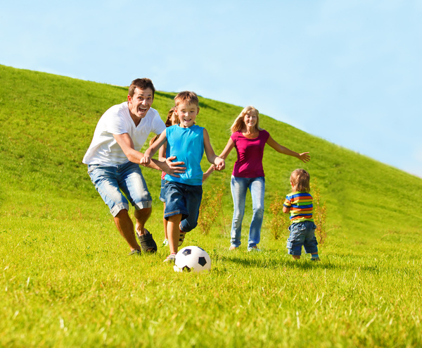 Parents with children playing football Stock Photo