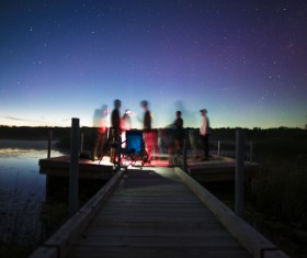 People gathering on river jetty at dusk Stock Photo