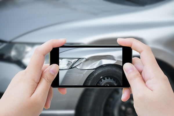 Photographing car accident scene with smartphone Stock Photo