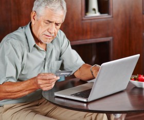 Senior man using laptop for online payment Stock Photo