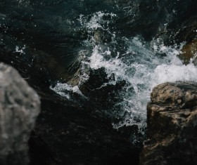 Splashing wave on rocks in sea Stock Photo