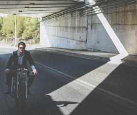 Stylish man riding motorbike on empty road Stock Photo