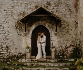 Wedding couple kissing in front of vintage building Stock Photo