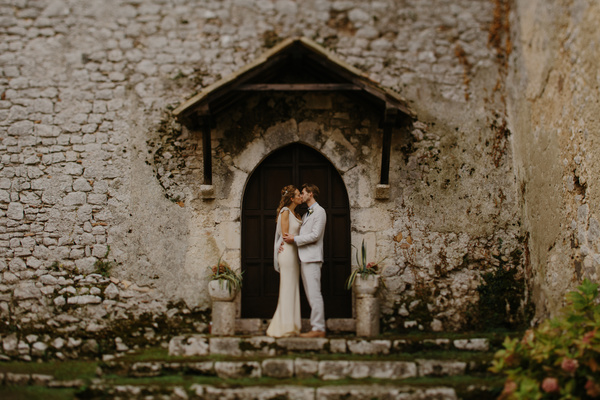 Wedding couple kissing in front of vintage building Stock Photo