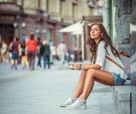 Woman Tourist sitting on the roadside Stock Photo