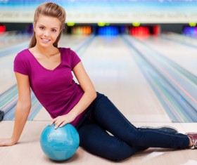 Woman holding a bowling ball sitting on the floor Stock Photo 03