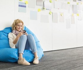 Woman playing smart phone while sitting in inflatable chair Stock Photo