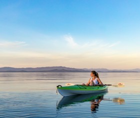 Woman rowing on calm river Stock Photo