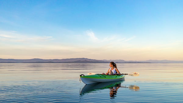 Woman rowing on calm river Stock Photo