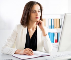 Woman sitting at computer and recording information Stock Photo