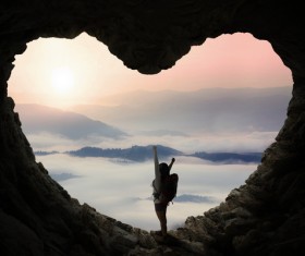 Woman standing in heart shaped cave mouth Stock Photo
