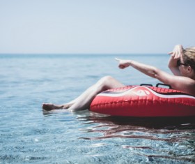 Young girl joyful on buoy on beach Stock Photo