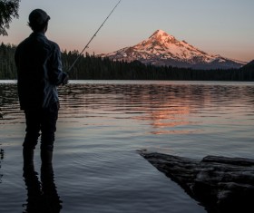 man fishing on calm lake Stock Photo