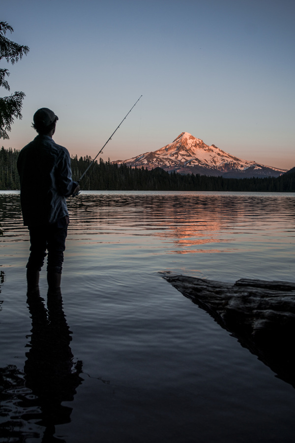 man fishing on calm lake Stock Photo
