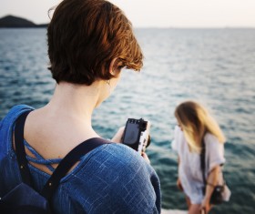 woman taking photograph on sea scene Stock Photo