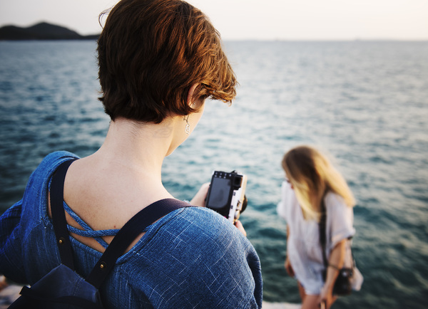 woman taking photograph on sea scene Stock Photo