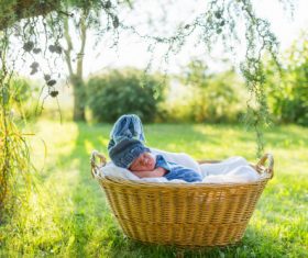 A baby sleeping in a wicker basket Stock Photo (1)