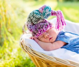 A baby sleeping in a wicker basket Stock Photo (3)