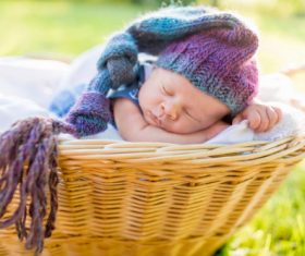 A baby sleeping in a wicker basket Stock Photo (4)