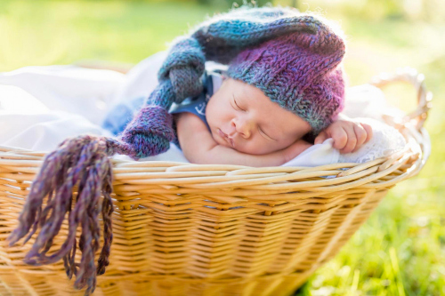 A baby sleeping in a wicker basket Stock Photo (4)