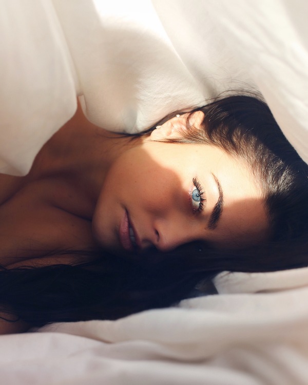 Attractive caucasian woman posing on bed Stock Photo