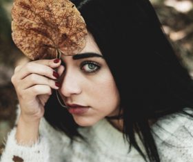 Attractive young woman posing with brown leaf Stock Photo