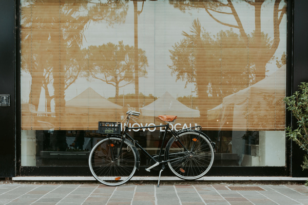 Bicycle leaning outside of glass door house Stock Photo
