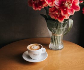 Coffee cup and decorative flowers on table Stock Photo