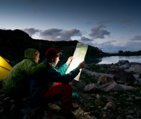 Couple looking at map outside camping tent Stock Photo