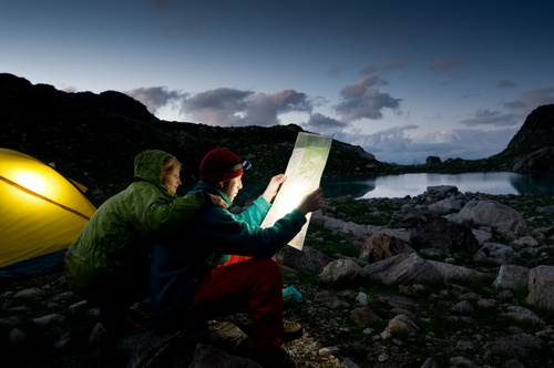 Couple looking at map outside camping tent Stock Photo