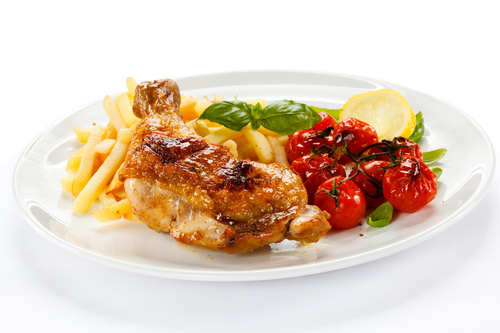 Delicious French fries and roasted chicken legs Stock Photo