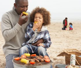 Father and daughter eating barbecue corn Stock Photo