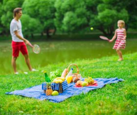 Father and daughter playing tennis and picnic food Stock Photo