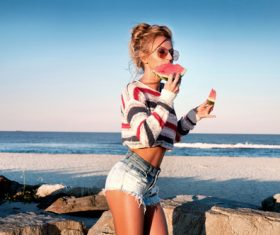 Girl eating watermelon while walking Stock Photo
