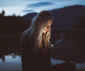 Girl using smartphone at dusk Stock Photo