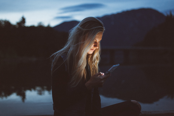 Girl using smartphone at dusk Stock Photo