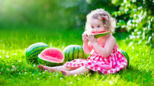 Joyful children are eating a watermelon Stock Photo (1)