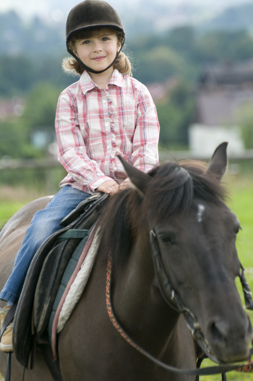 Little girl riding a horse Stock Photo