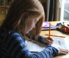 Little girl writing homework seriously Stock Photo