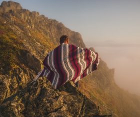 Lonely man posing in cloth on high mountain Stock Photo