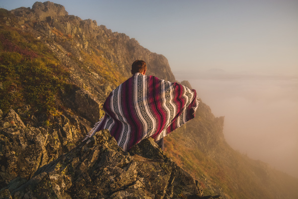 Lonely man posing in cloth on high mountain Stock Photo