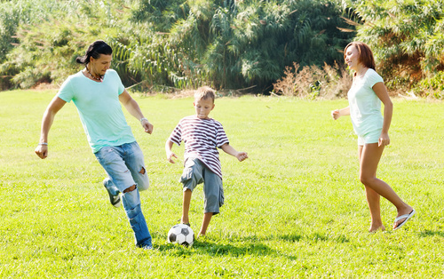 Parents and kids play football Stock Photo