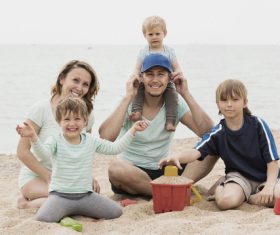 Parents playing with daughter on the beach Stock Photo 01