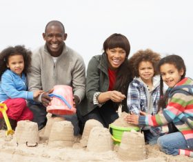 Parents playing with daughter on the beach Stock Photo 02