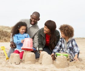 Parents playing with daughter on the beach Stock Photo 03