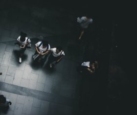 People walking on dark pavement from high view Stock Photo