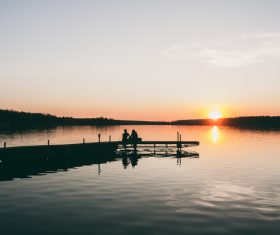 People watching sunset scenery on calm lake Stock Photo