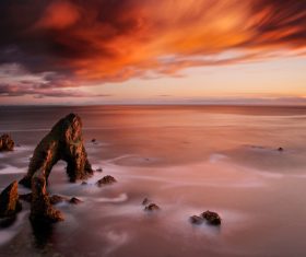 Rocky calm beach scenery at dusk Stock Photo