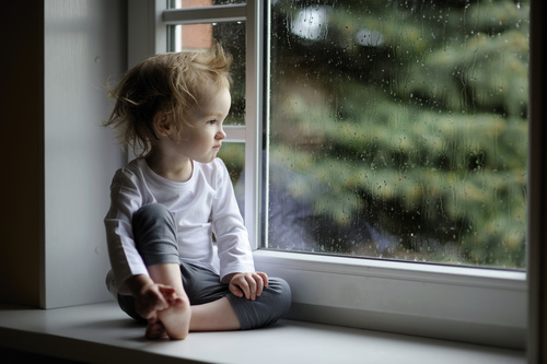 Sitting on the windowsill lonely children Stock Photo