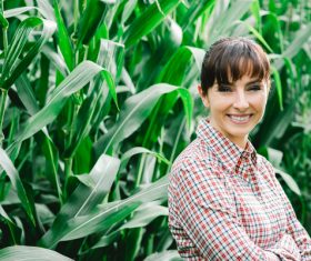 Smiling woman standing in corn field Stock Photo